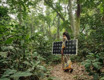 Woman carrying a solar panel near Yangammbi, IDRC (cred. Axel Fassio:CIFRO) via Flickr 