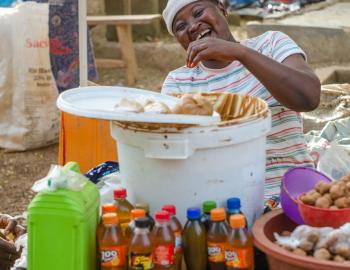 Trader selling groundnut paste at the local market in Ghana