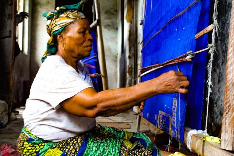 The Old Woman and the Loom: The old woman weaves at a loom in her house in Akwete, Abia State in Eastern Nigeria.